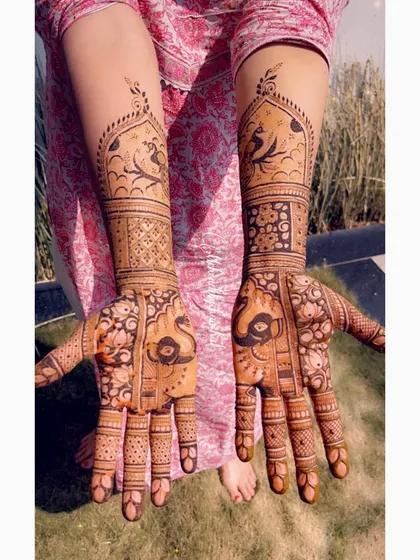 A full view of the bridal mehendi with peacocks and elephants, captured outdoors.