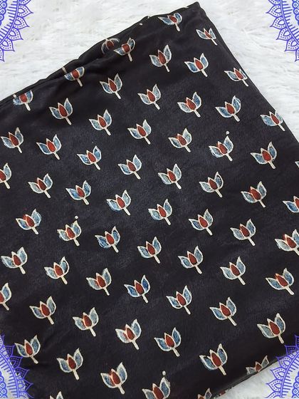 A classic black Ajrakh fabric with a delicate floral buti print. This versatile fabric can be used to create a variety of ethnic and fusion wear.