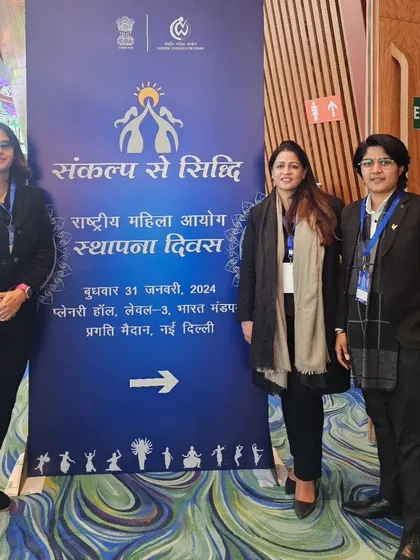Posing with the official banner for the National Commission for Women Foundation Day.