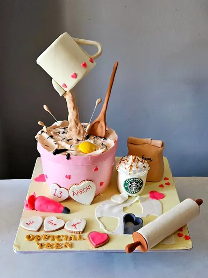 This cake was a joy to create for a young baker celebrating her 13th birthday. It features a gravity-defying design with a pouring mug, alongside edible baking tools like a rolling pin, piping bag, and even a miniature Starbucks cup. It’s a playful and complex piece that shows how we can turn any passion into a delicious work of art.