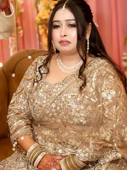 A golden goddess for her engagement. This look features a heavily embroidered golden lehenga with dramatic eye makeup and soft waves.