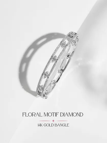 A clean product shot of the Floral Motif Diamond Bangle. Crafted in 14k gold, this piece features a delicate floral pattern etched in diamonds for everyday elegance.
