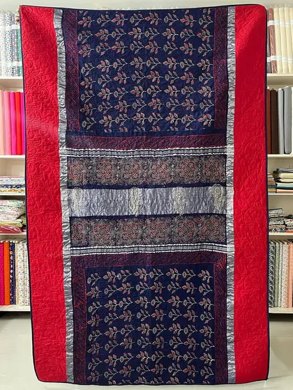 A striking red and blue saree quilt, demonstrating how we handle vibrant silk fabrics.