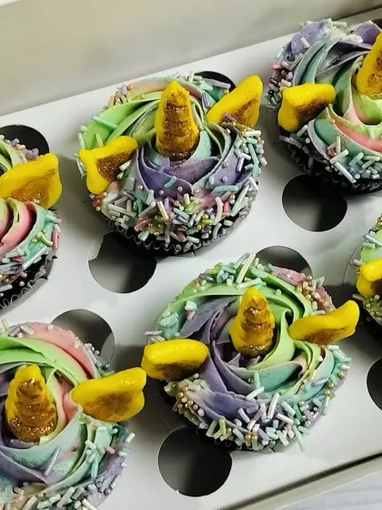 These magical unicorn cupcakes are one of my most requested designs for kids' parties. Each chocolate cupcake is decorated with a beautiful pastel rainbow swirl of buttercream, edible sprinkles, and a golden fondant horn and ears, making them a truly enchanting treat.