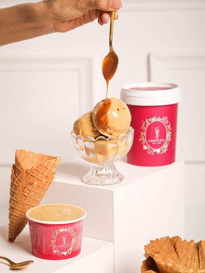 A scoop of our rich, artisanal ice cream being drizzled with caramel. Our ice cream tubs are perfect for enjoying slow, satisfying scoops of your favourite flavours.