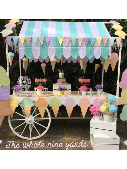 An adorable ice cream cart setup for a first birthday. The pastel colors, giant ice cream cone props, and themed desserts made for a sweet and memorable celebration.
