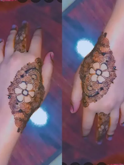 This design features a central flower enclosed in a diamond-shaped pattern filled with fine details. It's a unique and eye-catching style for the back of the hand.