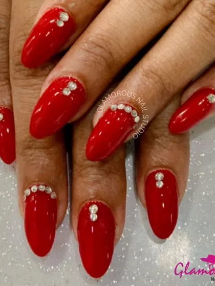 Simple, yet so glamorous. These classic glossy red nails are elevated with carefully placed rhinestones at the cuticle and on accent nails, proving that a little bit of sparkle can make a big impact.