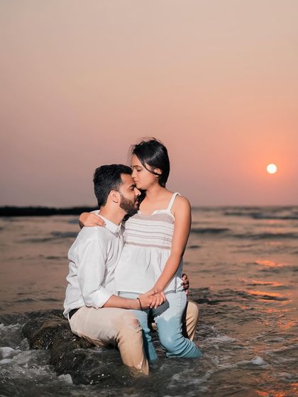 Another angle of the romantic sunset kiss. This close-up focuses on the intimacy of the moment, with the beautiful orange sky in the background.