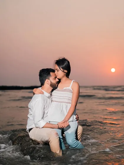 Another angle of the romantic sunset kiss. This close-up focuses on the intimacy of the moment, with the beautiful orange sky in the background.