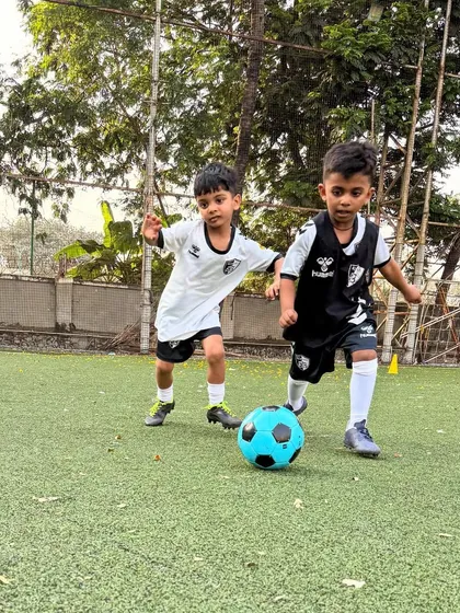 Two players challenge for the ball, showing the determination and competitive edge we nurture in our young athletes.