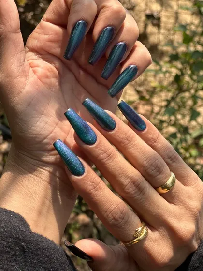 This peacock nail set is pure magic. Using a special cat-eye polish, the colors shift from deep blue to vibrant green depending on the light. It's a long-lasting gel extension look that guarantees compliments.