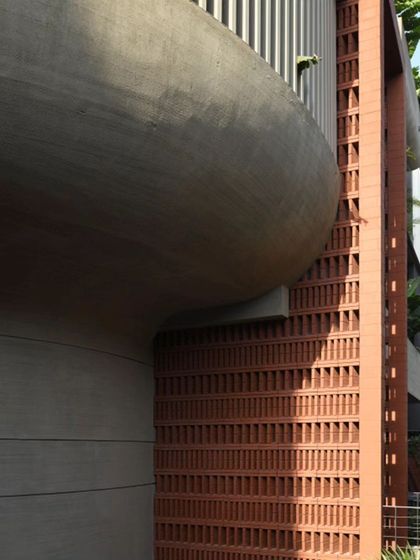 A close-up of a facade that weaves exposed concrete and rustic brick together. This juxtaposition of rough, earthy brick with smooth, modern concrete results in an understatedly sophisticated aesthetic that is rich in texture and character.
