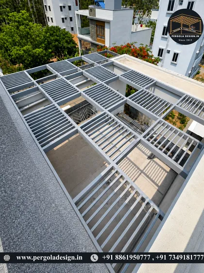 An aerial view of a modern louvered pergola structure. The sleek grey finish and parallel slats offer a contemporary look while providing adjustable shade, making it a perfect addition to any modern home's rooftop.