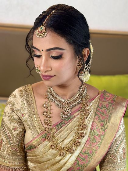 This look for Dr. Pooja's muhurtham is all about that bridal glow. The glowing skin, combined with a traditional braided hairstyle adorned with fresh jasmine, creates a picture-perfect South Indian bridal style.