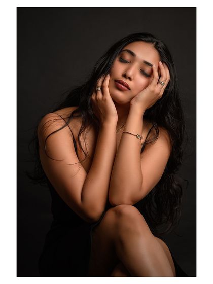 A simple and elegant portrait against a dark background. The focus is on the model's serene expression and natural beauty.