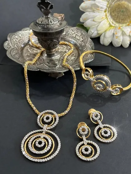 Complete your look with elegance. This modern diamond set, featuring a concentric circle design, includes a bracelet, necklace, and earrings for a coordinated and timeless look.
