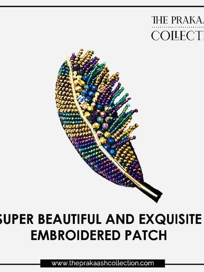 A close-up of our exquisite embroidered feather patch. Made with iridescent beads in shades of purple, green, and gold, this beautiful appliqué can be sewn on to add a touch of elegance.