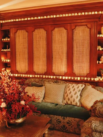 A cozy seating area illuminated by dozens of candles, creating a warm and inviting atmosphere for a Diwali event.