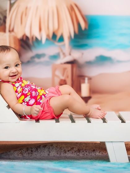 A relaxed and happy baby enjoying her studio beach day. Her cheerful smile shows just how much fun these imaginative sessions can be.