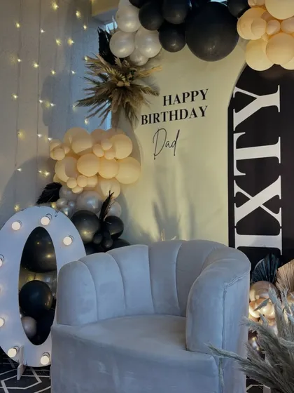 A close-up of the 60th birthday photo booth, highlighting the custom backdrop and the large, illuminated '60' marquee numbers.