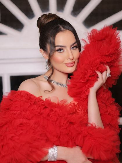 A soft yet glamorous look for a cocktail event. This ruffled red gown is pure drama and elegance, styled with a clean high bun and sparkling diamond jewelry to let the outfit do all the talking.
