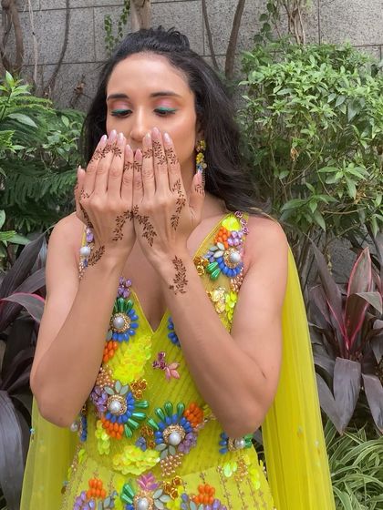 Another shot focusing on the delicate mehendi and the colorful eye makeup that adds a playful touch to the look.