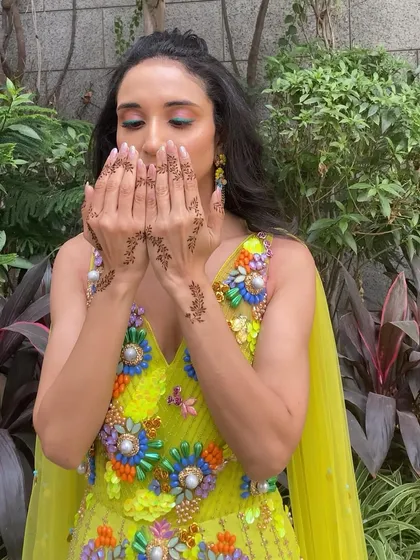 Another shot focusing on the delicate mehendi and the colorful eye makeup that adds a playful touch to the look.