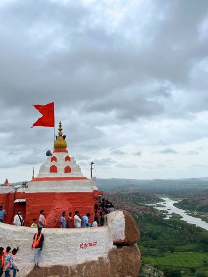 The Anjanadri Hill temple in Hampi, perched on a rocky outcrop with the Tungabhadra river snaking below.