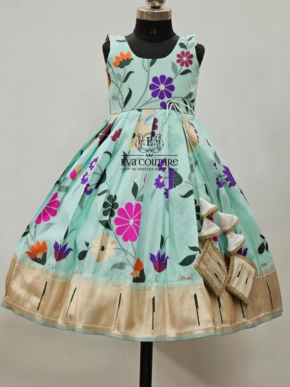 A sleeveless one-piece frock with a beautiful pastel blue floral print and a Kanchi border.