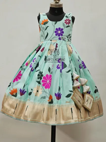 A sleeveless one-piece frock with a beautiful pastel blue floral print and a Kanchi border.