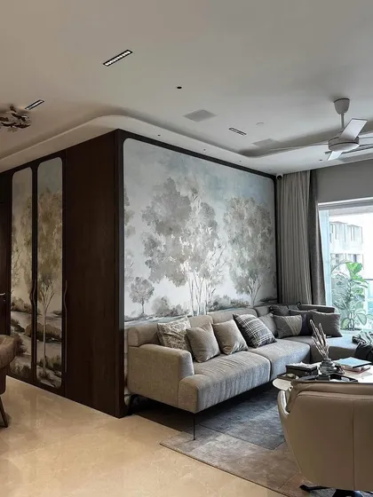 A wider view of the living and dining area shows how our artisanal wallpapers can seamlessly connect different zones. The continuous landscape mural, framed in dark wood, acts as a sophisticated, unifying element throughout the space.