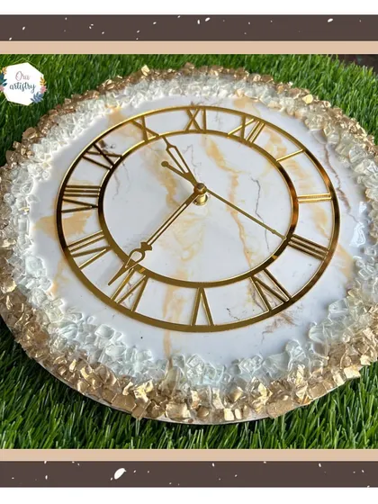 A framed view of a beautiful gold and white resin clock, highlighting its elegance.