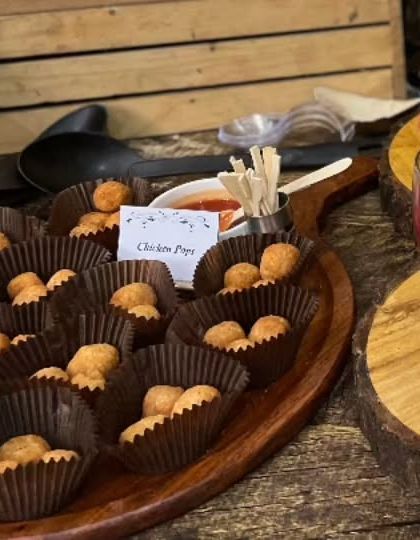 Bite-sized Chicken Pops served in individual paper cups. These are a perfect, mess-free savory snack for a children's birthday party.