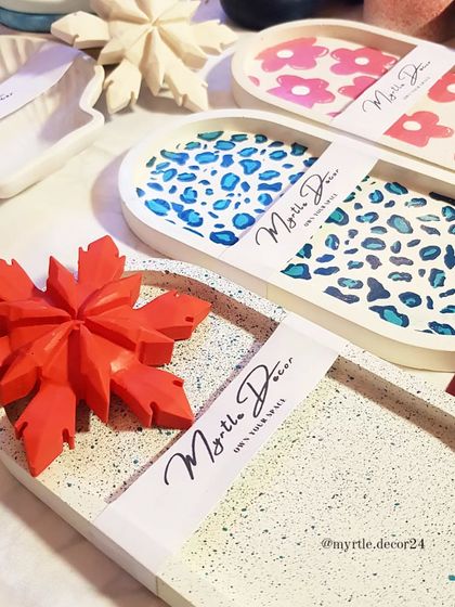 Our custom-painted oval trays, featuring a terrazzo finish, a blue leopard print, and a pink floral design.
