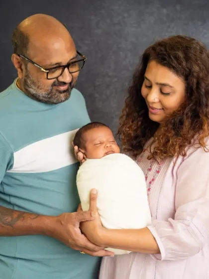 A beautiful portrait of a couple cherishing their newborn baby. Their gentle hold and soft smiles perfectly capture the love in their new family.