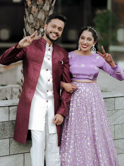 The couple posing with peace signs, a fun and modern portrait from their engagement or reception party.