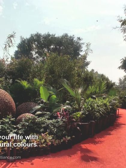 We celebrate life with vibrant natural colors. This red pathway winds through a lushly planted garden, showcasing our use of bold color and natural textures to create joyful and enriching landscapes.
