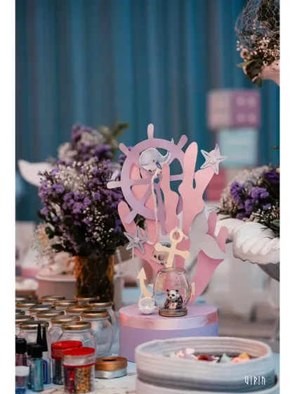 An activity table set up for the kids, featuring ocean-themed crafts and jars of supplies. I believe in providing creative and engaging activities to keep the little ones entertained.