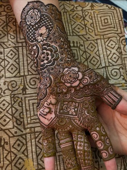 A close-up of the palm, showing the intricate details and the groom's name hidden within the design.