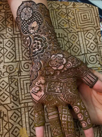 A close-up of the palm, showing the intricate details and the groom's name hidden within the design.