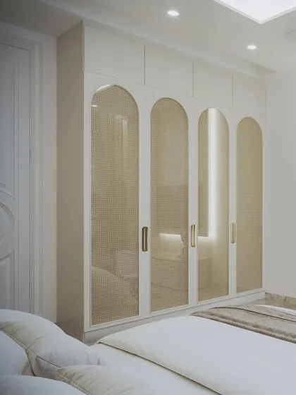 This shot highlights the arched, cane-paneled wardrobe doors, adding a touch of softness and texture to the minimalist room.