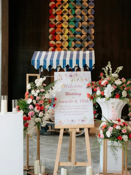 This welcome setup combines classic floral arrangements with a charming, retro-style cart, adding a unique and personal touch to the entrance.