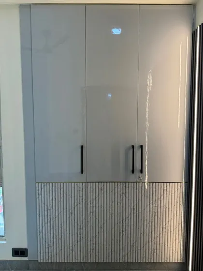A four-door wardrobe with a modern design, combining high-gloss grey laminate on top with a textured, fluted panel at the bottom.