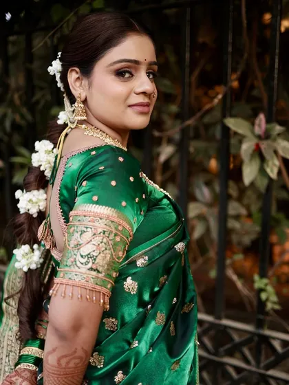 A back view showcasing the elegant braided hairstyle adorned with fresh gajra, a classic choice for Maharashtrian brides that adds fragrance and beauty.