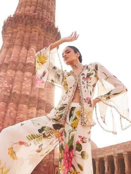 A model strikes a pose in a floral print co-ord set with a jacket, its bell sleeves adding a touch of drama.