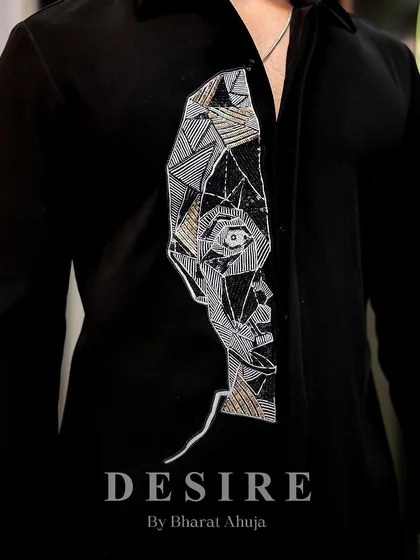 Another detail shot of the abstract face shirt, highlighting the mix of threadwork and sequins that create its unique texture.