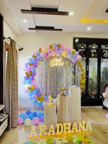 A full view of the pastel butterfly themed first birthday decoration. The circular frame, shimmer backdrop, and balloon arrangement create a dreamy photo corner for the celebration.