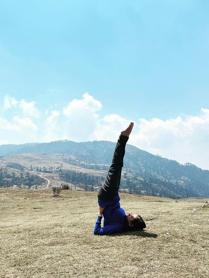 Sarvangasana, or Shoulder Stand, in the open air. This pose is known as the "queen of asanas" for its many benefits, including calming the nervous system and balancing hormones.