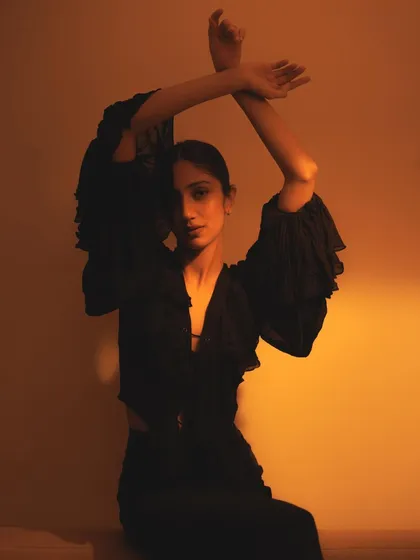 Using the arms to frame the face, this shot is all about form and silhouette. The warm lighting and dark clothing create a beautiful, high-contrast image.